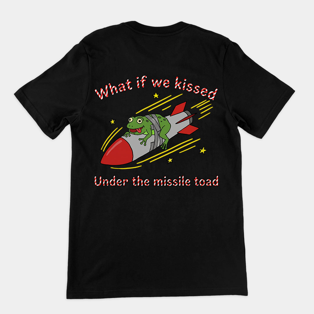 Black t-shirt featuring a funny holiday pun design with a frog riding a rocket and text WHAT IF WE KISSED UNDER THE MISSILE TOAD.