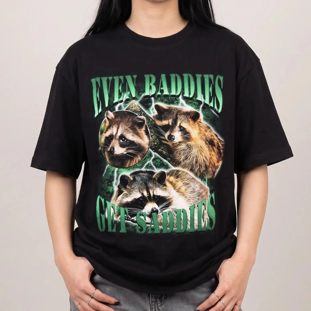 Model wearing the Even Baddies Get Saddies t-shirt in black, studio photo