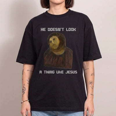 He doesn't look a thing like Jesus Funny T-Shirt - Orbital Clothing