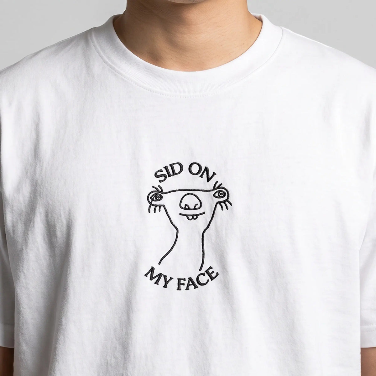 Sid on my face embroidered t-shirt in white, worn, close-up of the stitching
