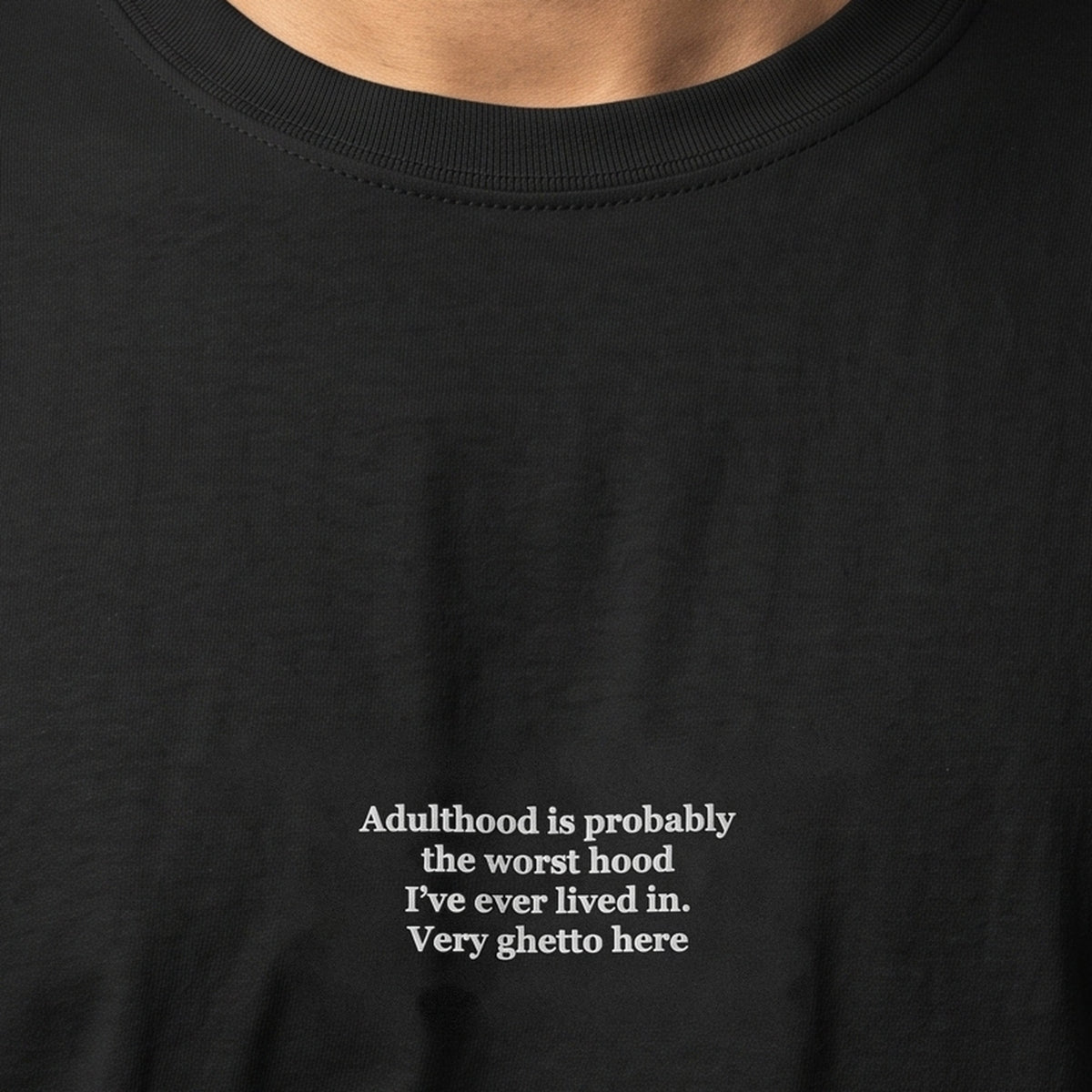 Adulthood is probably the worst hood I've ever lived in. Very ghetto here (embroidered) T-Shirt in black, worn, close-up of the stitching
