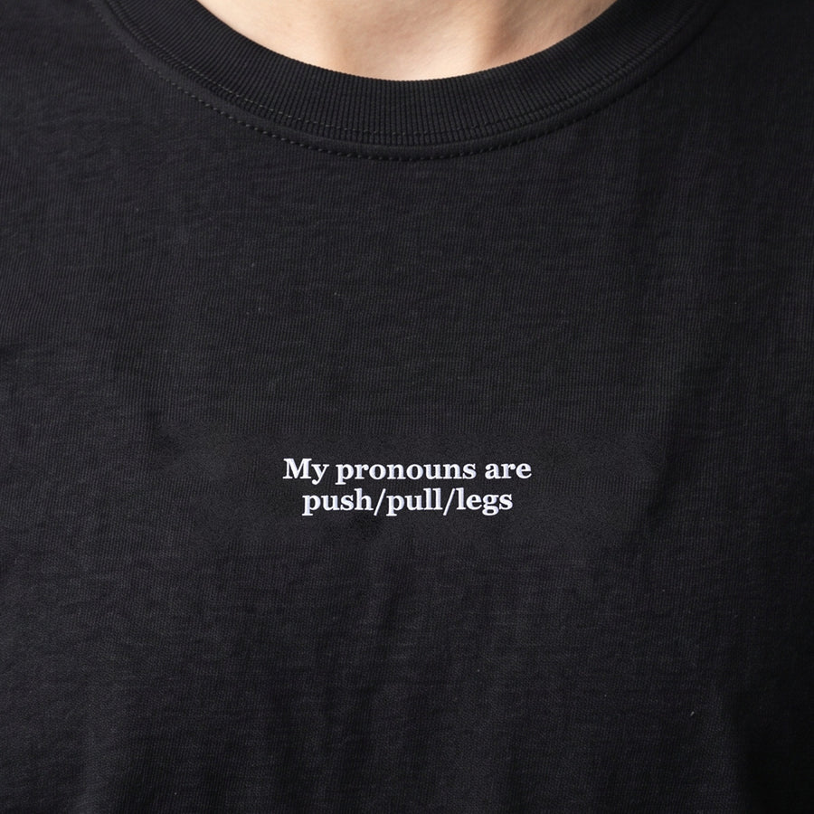 My pronouns are push/pull/legs (embroidered) T-Shirt in black, worn, close-up of the stitching