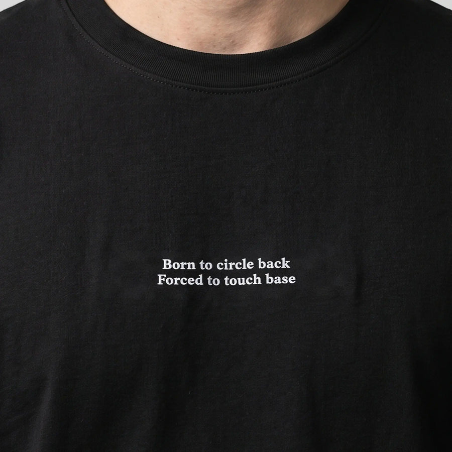 Born to circle back forced to touch base embroidered t-shirt in black, worn, close-up of the stitching