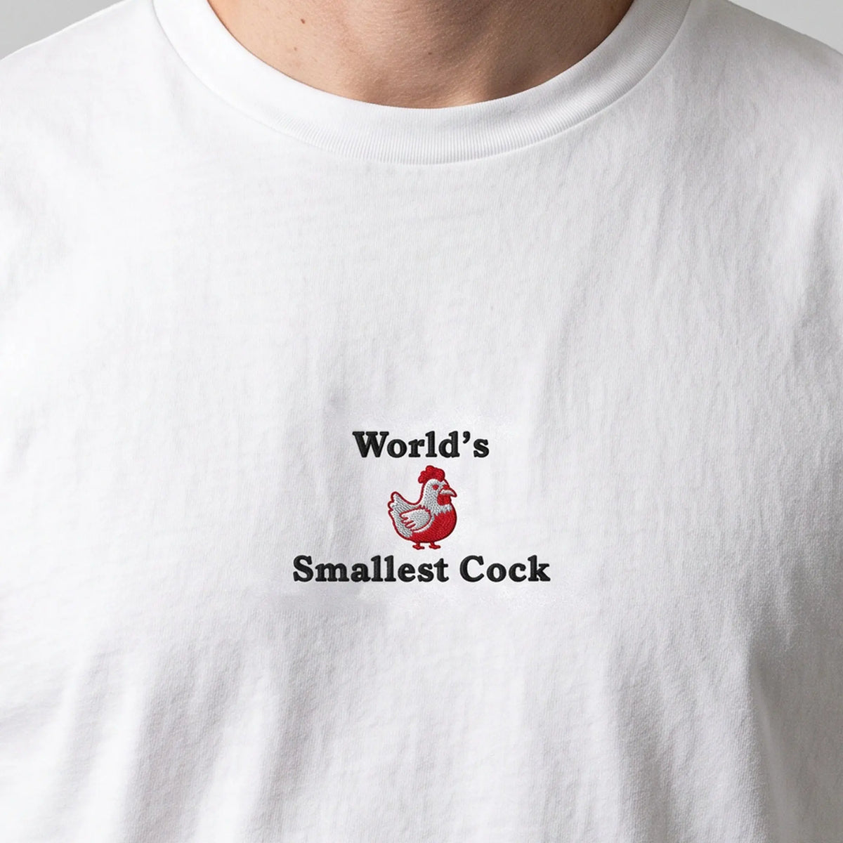 World's Smallest Cock (embroidered) T-Shirt in White, worn, close-up of the stitching