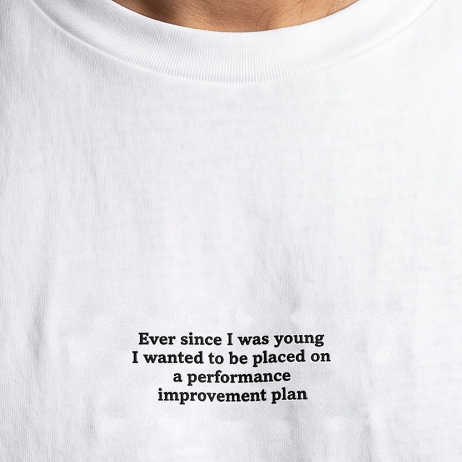 Ever since I was young I wanted to be placed on a performance improvement plan embroidered t-shirt in white, worn, close-up of the stitching
