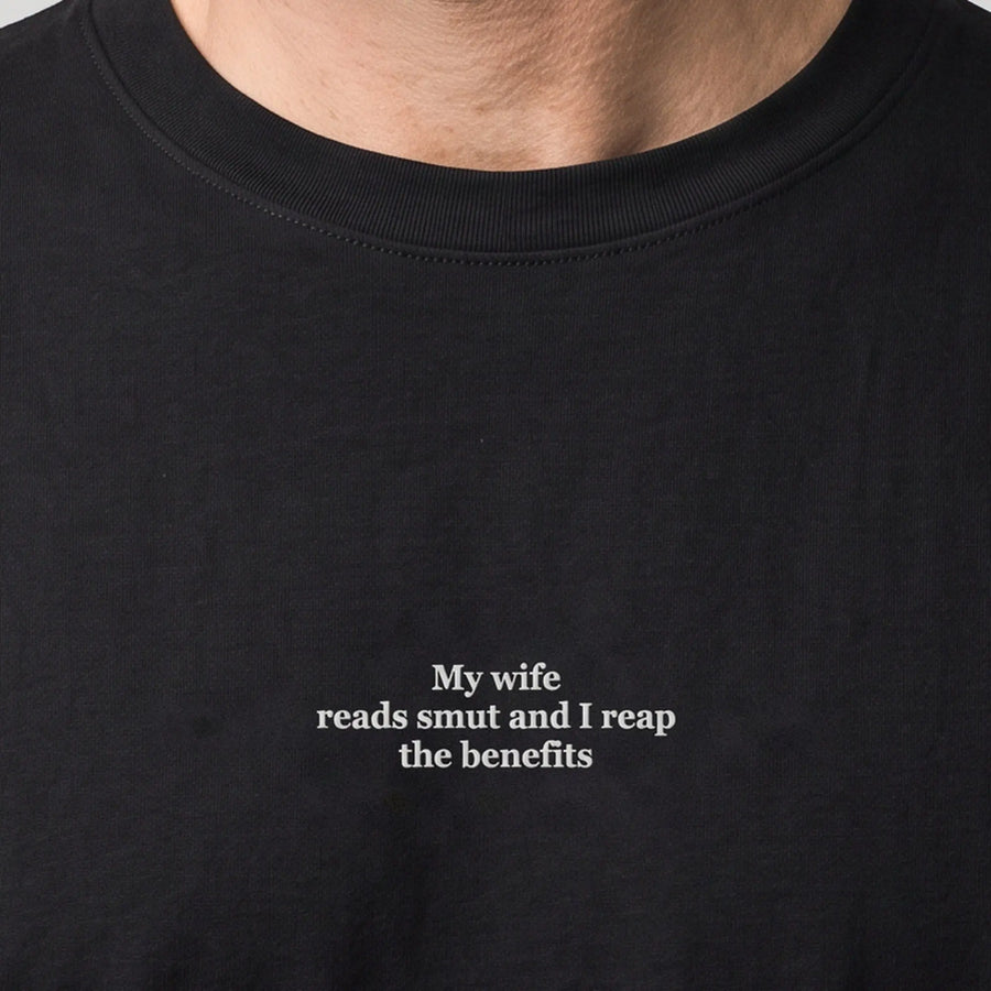 My wife reads smut and I reap the benefits (embroidered) T-Shirt in black, worn, close-up of the stitching