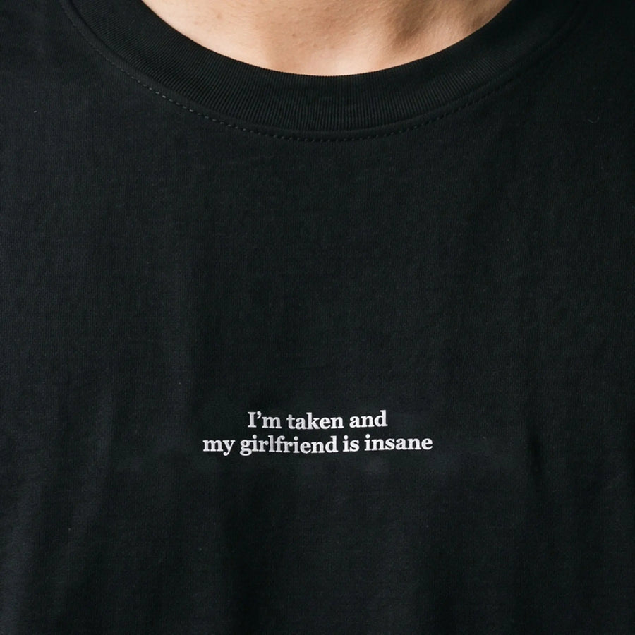 I'm taken and my girlfriend is insane (embroidered) T-Shirt in black, worn, close-up of the stitching