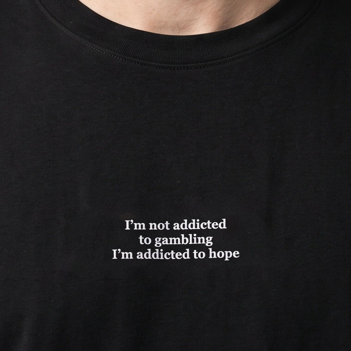 I'm not addicted to gambling I'm addicted to hope (embroidered) T-Shirt in Black, worn, close-up of the stitching