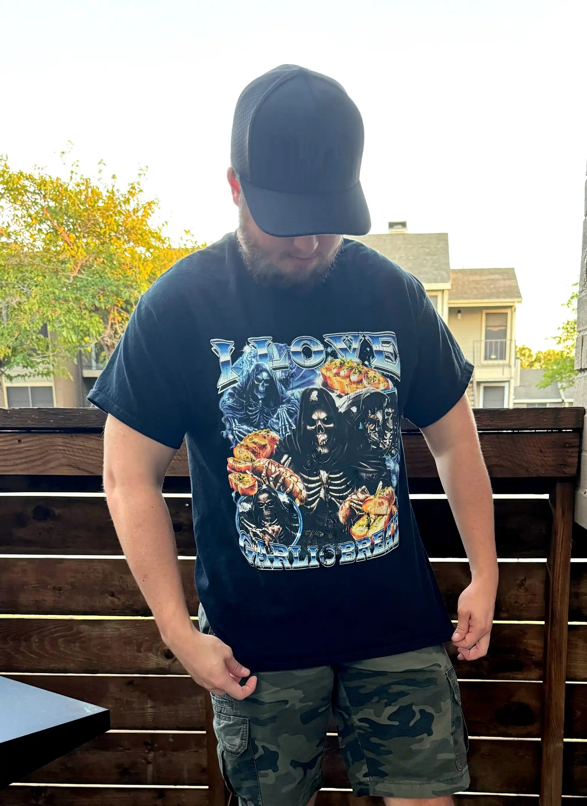 Man wearing a black I LOVE GARLIC BREAD graphic t-shirt featuring skeletons and garlic bread design.