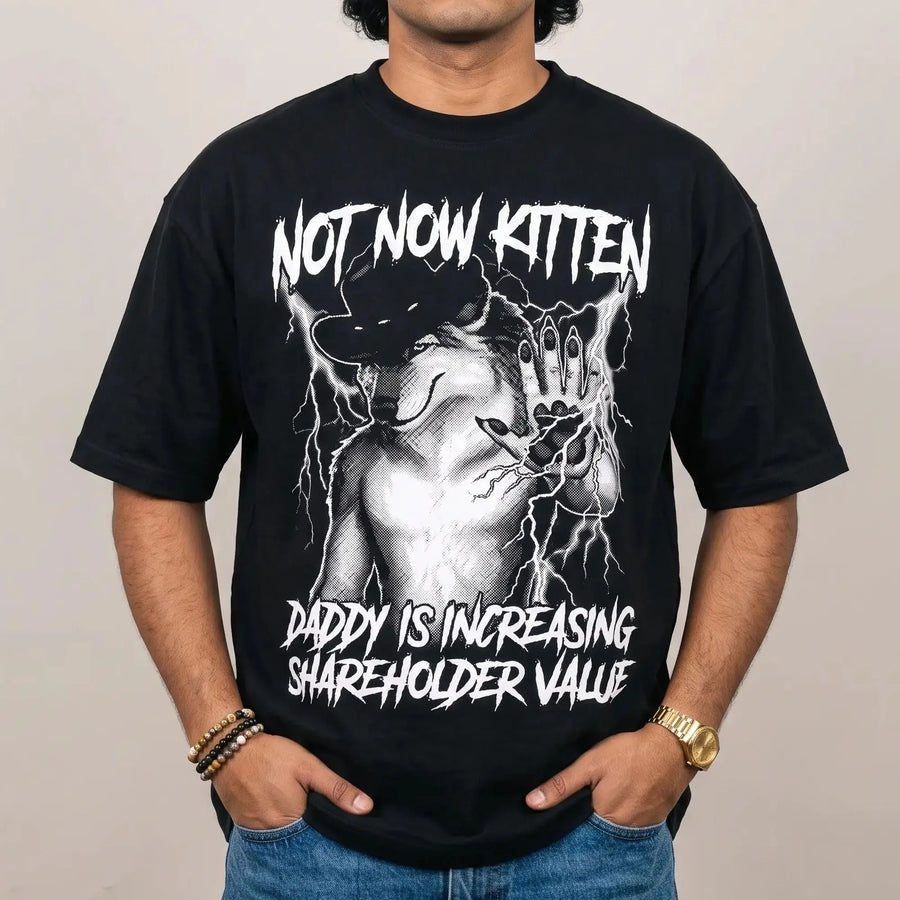 Model wearing the Not Now Kitten Daddy is Increasing Shareholder Value T-Shirt in black, studio photo